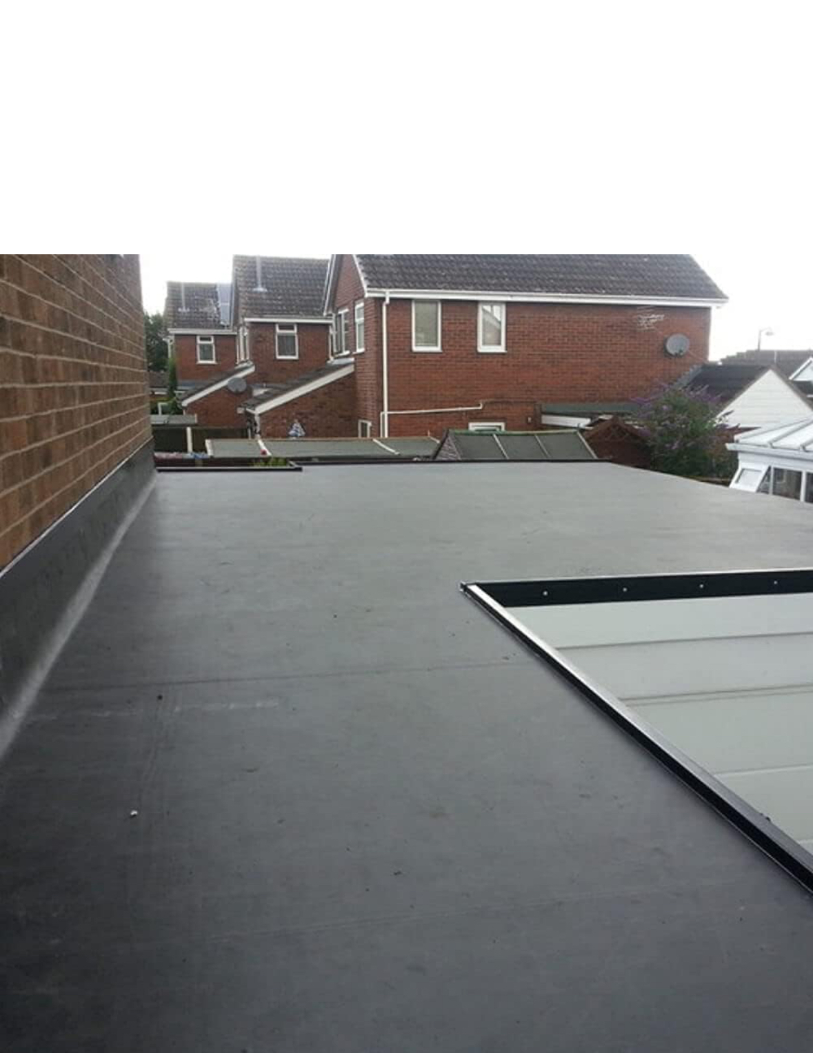 Finished flat roof against a brick wall with clean upstand detail