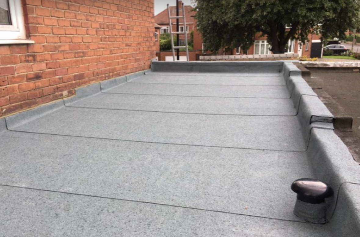 Flat roof with felt bays, parapet edges, and outlet detail