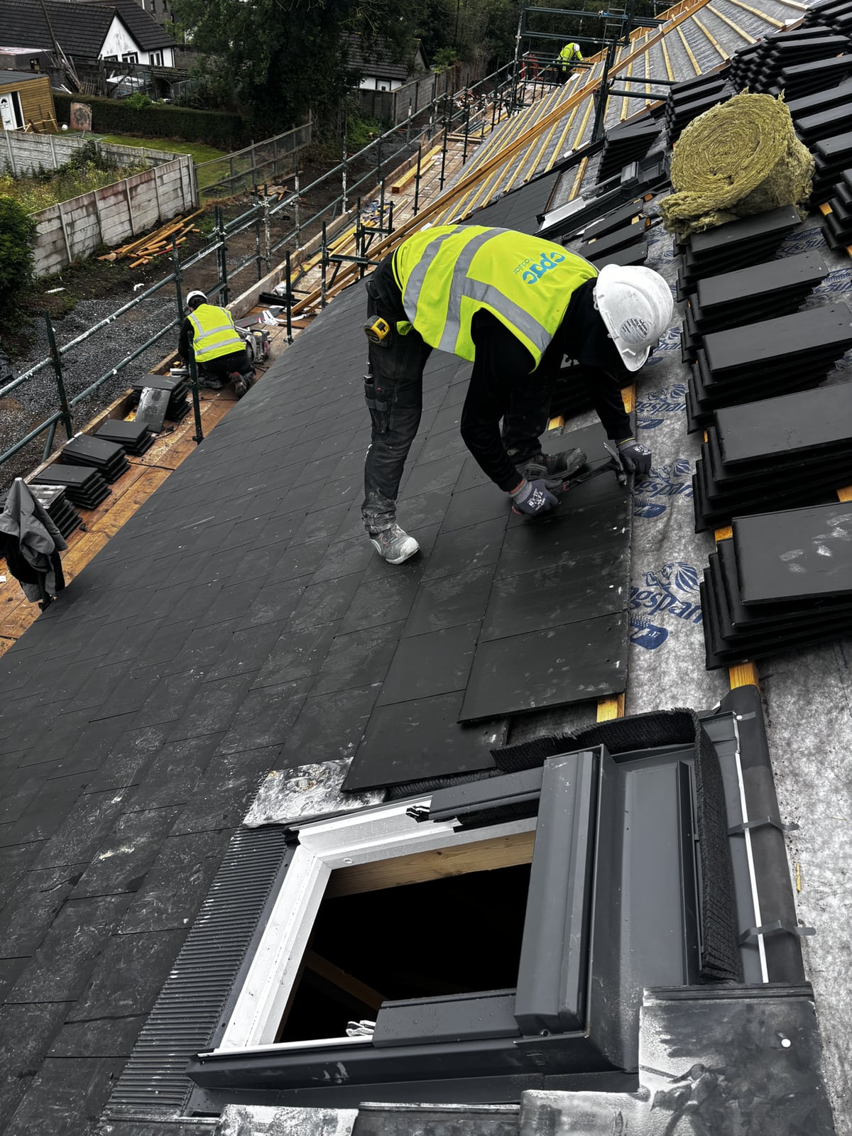 Perfect Roofing team installing black roof slates on a North Dublin pitched roof
